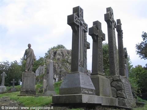Stone Celtic crosses and statue among rocks in the old graveyard