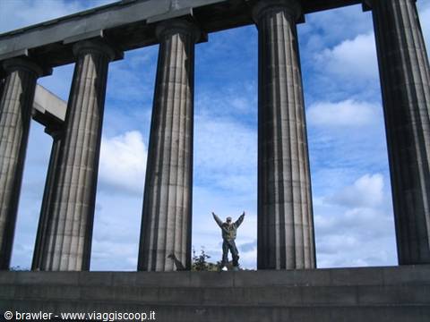 Tourist with raised arms between the Doric columns of the National Monument, Calton Hill, Edinburgh