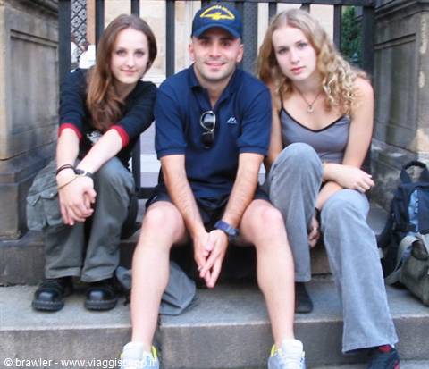Three friends sitting on stone steps, one wearing a blue cap
