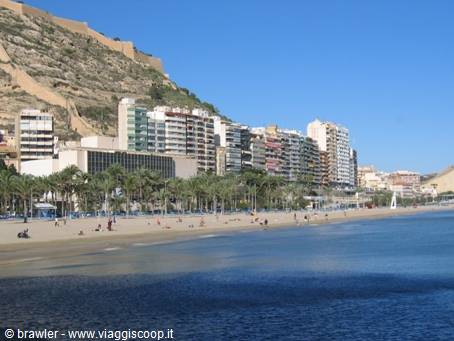Alicante city beach with palms, high-rise buildings and castle on the rock