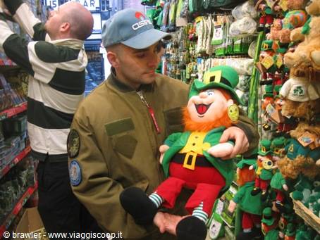 Tourist holds a green leprechaun plush among souvenirs in a shop
