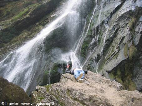 Tourist sitting on the rock beneath Powerscourt waterfall