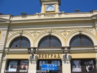 Yellow facade of Belgrade station with clock and Cyrillic sign