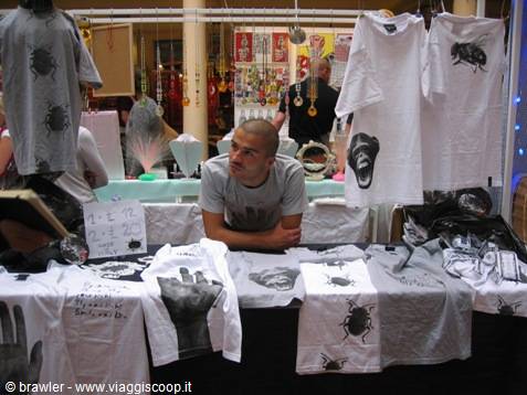 Young vendor at a stall with printed t-shirts, indoor market