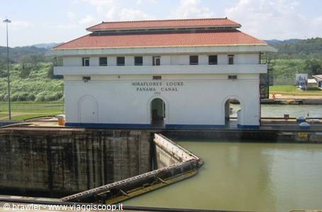 The white Miraflores Locks building on the Panama Canal with the dam