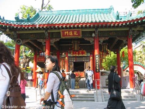 Tourist walks past the red Wong Tai Sin Temple in Hong Kong