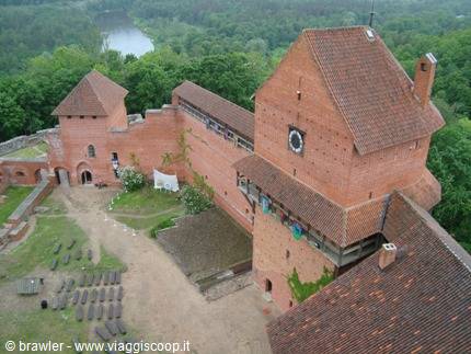 Turaida Castle: red brick towers rising above forest and the Gauja river