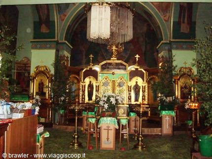 Golden iconostasis with icons, chandelier and flowers inside Sofia's Orthodox church