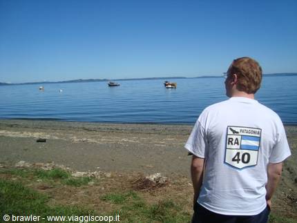 Boy in Ruta 40 shirt watches boats from Espolon beach