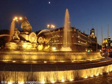 Cibeles Fountain lit at night with water jets and palace behind