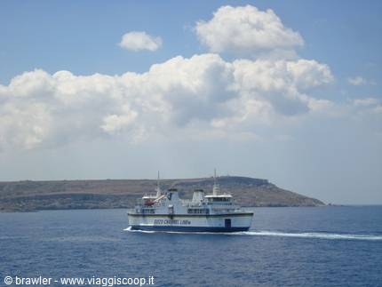 Gozo Channel ferry sails across blue sea before a rocky coastline