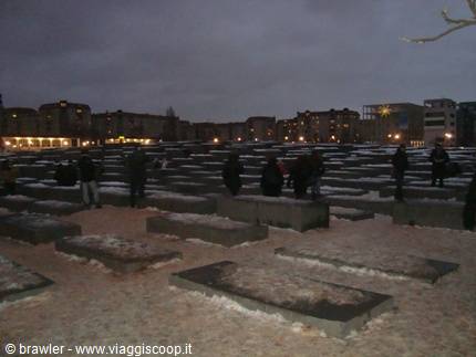 Visitors among the concrete slabs of the Holocaust Memorial in Berlin, at dusk