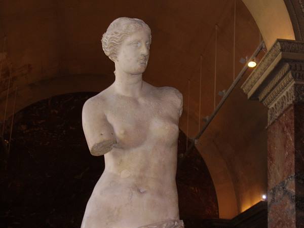 The Venus de Milo at the Louvre, marble statue without arms in warm light