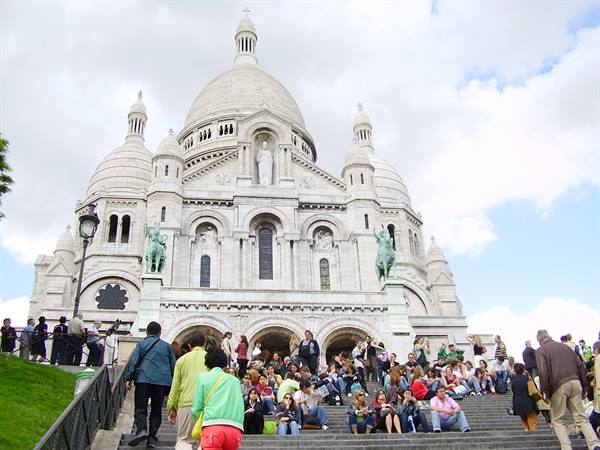 Tourists sitting on the steps in front of Sacré-Cœur, Montmartre, Paris