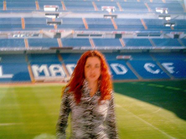 Red-haired woman on the pitch of the Santiago Bernabéu stadium
