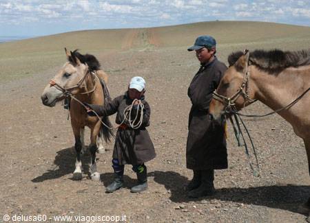 Child and young nomad with horses on the Mongolian steppe