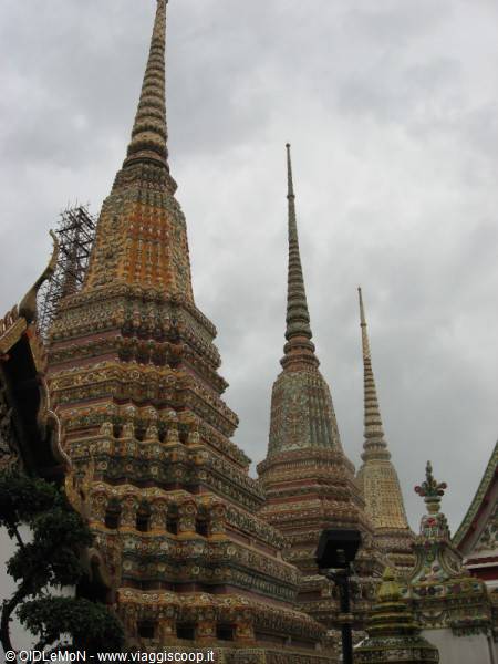 Wat Pho: ornate tiled stupas rising under a cloudy sky