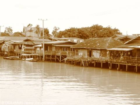 Wooden stilt houses lining the water, ladder down to the river