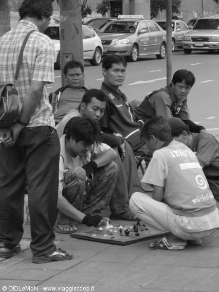 Group of men playing street chess on the sidewalk, black and white