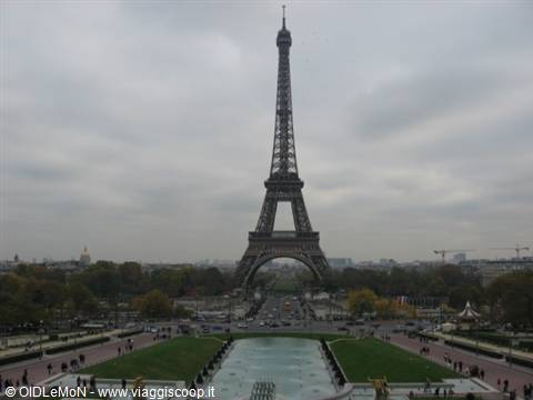 The Eiffel Tower seen from the Trocadéro gardens with fountains and cloudy sky