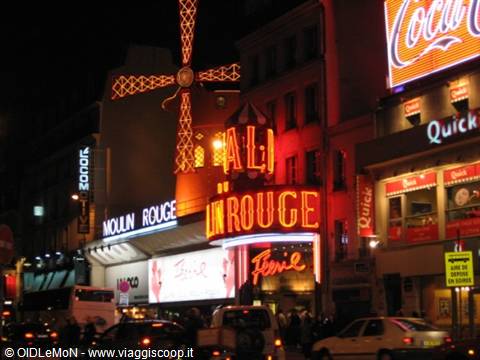 The illuminated red windmill of the Moulin Rouge at night