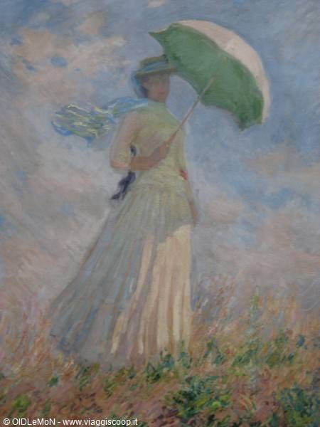 Impressionist painting of woman in white dress with green parasol by Monet