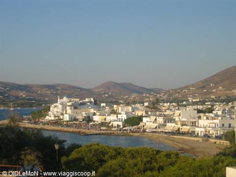 Whitewashed town by the harbor, cubic houses, dry hills, warm afternoon light