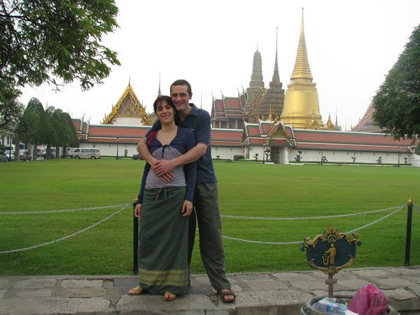 Couple embracing in front of the golden stupa of Wat Phra Kaew, Bangkok