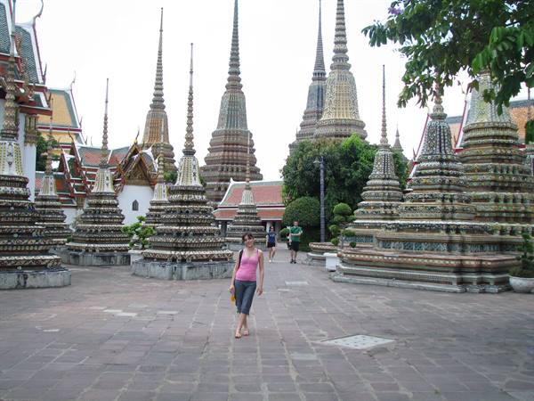 Tourist walks among mosaic-decorated stupas at Wat Pho, Bangkok