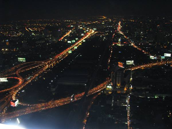 Highway interchanges glowing with car headlights in Bangkok night
