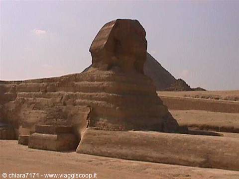 The Great Sphinx of Giza in limestone, pyramid behind, harsh sunlight