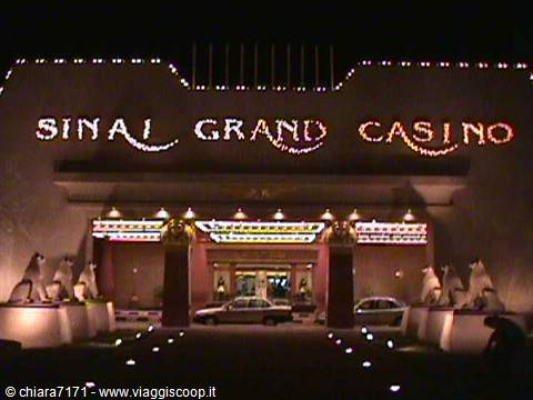 Illuminated Sinai Grand Casino sign at night with cars parked at the entrance