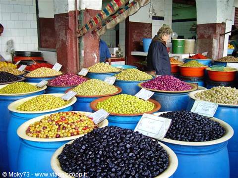 Colorful olives in blue buckets at a Marrakech souk market stall