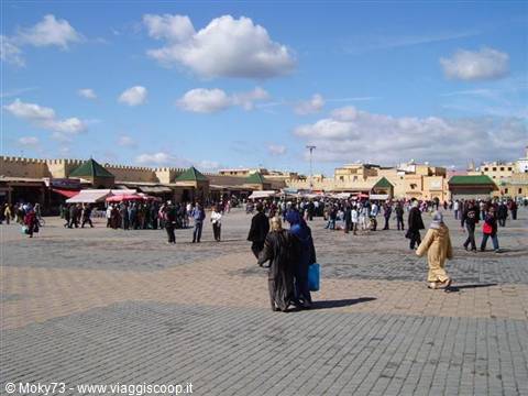 Tourists and locals stroll across El Hedim square in Meknès among ochre walls and market stalls