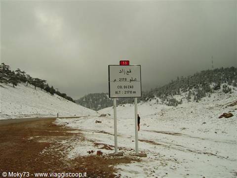 Road sign at snow-covered Col du Zad pass, 2178 meters, overcast sky