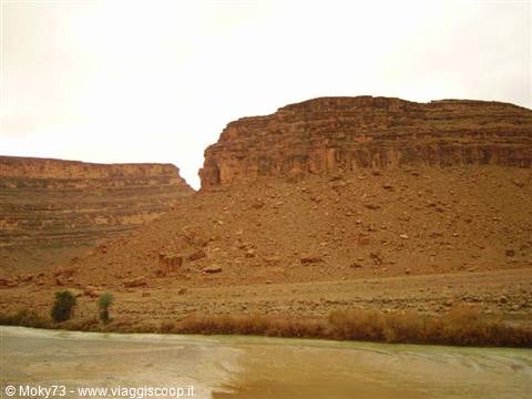 Ancient red-earth kasbah ruins beside the muddy river