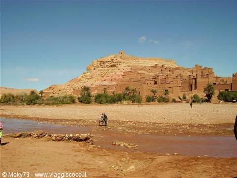 Aït Benhaddou, mud-brick kasbah above the river, tourists crossing the ford