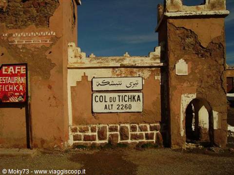 Earthen gateway at Col du Tichka, 2260 m, café sign and bilingual road sign