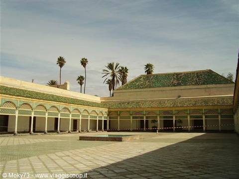 Bahia Palace courtyard in Marrakech, arched arcades, green tiled roofs, palms