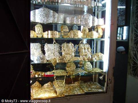 Lit shop window displaying traditional gold bracelets and jewelry in a souk