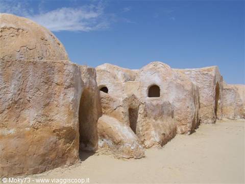 Traditional clay granaries in the desert, possibly Ksar Medenine, under blue sky