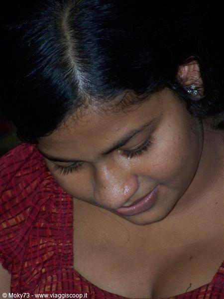 Close-up portrait of a smiling woman, black hair, silver earring