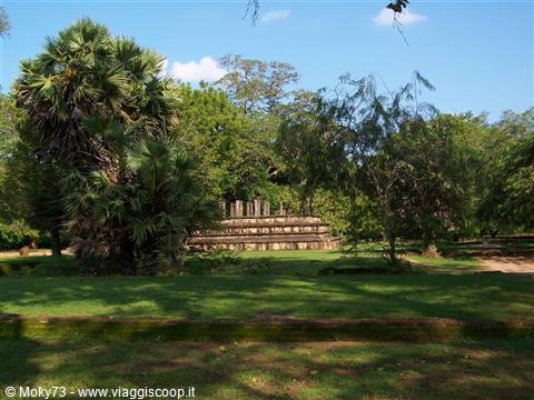 Ancient stone ruins amid lush trees and green lawn, Polonnaruwa