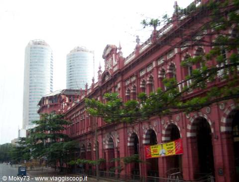 Pink colonial arched building in Colombo, modern skyscrapers in the background
