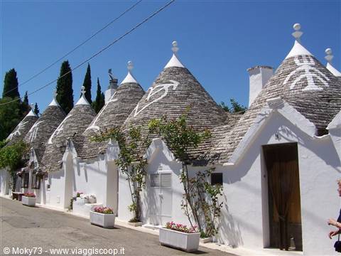 Trulli of Alberobello, conical stone roofs with white symbols under the sun