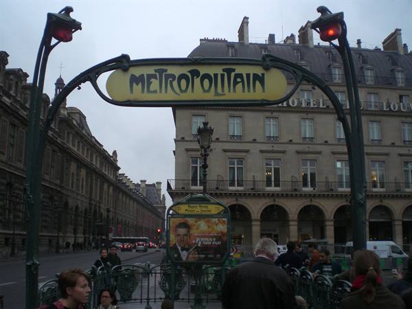 Art Nouveau Metropolitain sign in Paris, Rue de Rivoli, grey light and pedestrians