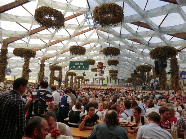 Crowded beer hall tent with wreath decorations and Block C, B, A sign