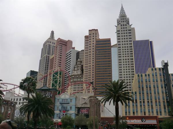 New York-New York hotel in Las Vegas with skyscrapers, roller coaster and palm trees
