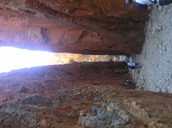 Hikers between red rock walls in a narrow gorge