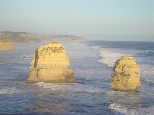 Twelve Apostles limestone stacks among ocean waves in golden morning light